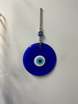 Blue glass evil eye wall hanging measuring 22 cm shown against a feature wall as protective home decor