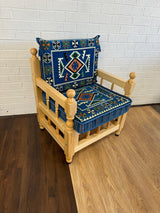 Blue rhombus floor cushion set with geometric diamond cotton cover on a rustic wood chair in a modern majlis