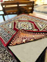 Deep maroon cotton floor cushion styled near a low table in a palace-style seating corner