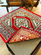 Rich red cotton floor cushion styled near a low table in a palace-style seating corner