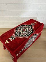 Red Palace armrest cushion in 100% cotton with ornate pattern beside majlis floor cushions