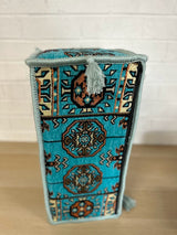 Side view of aqua armrest cushion showing firm sponge shape and stitched cotton cover edges