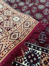 Burgundy Turkish cotton kilim rug placed in a high traffic living area beside warm wood furnishings