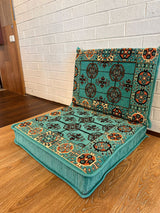 Aqua cotton floor cushion set styled against a wall as a relaxed reading nook on the floor