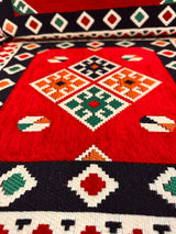 Detail of red square floor cushion showing clean square motif and firm sponge edge on red cotton cover