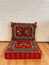 Red floor cushion set with warm red cotton seat base and matching backrest arranged for welcoming floor seating