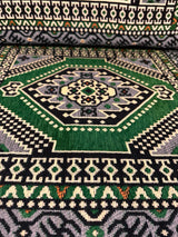 Close cotton-weave detail of green floor cushion showing firm sponge fill and stitched seam on natural cover
