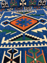 Detail of blue rhombus floor cushion showing woven diamond motif and firm sponge edge on cotton cover