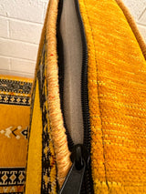 Yellow palace floor cushion shown against a wall as standalone ground seating without furniture