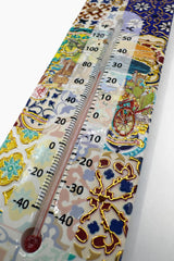 Close view of the mosaic wall thermometer tilework, colourful pieces set around a vertical temperature scale