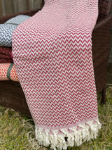 Close detail of the red handwoven cotton throw showing the hand-loomed weave and texture of natural cotton fibre