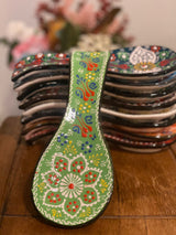 Handpainted light green ceramic spoon holder shown from above, a long rest for cooking spoons in a soft pale glaze
