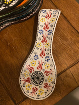 Close-up of the white glazed ceramic spoon holder highlighting hand-painted detail and clean finish